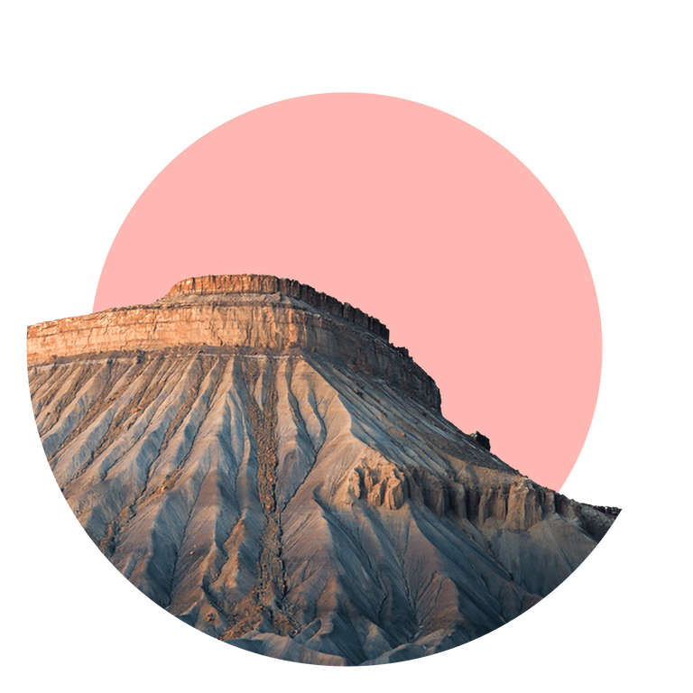 The rocky bluff of Mount Garfield near Grand Junction, with the sky cropped and overlaid with a pink circle.